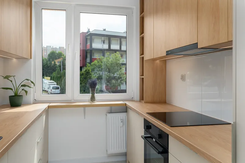Cocina en L con ventana y encimera de madera