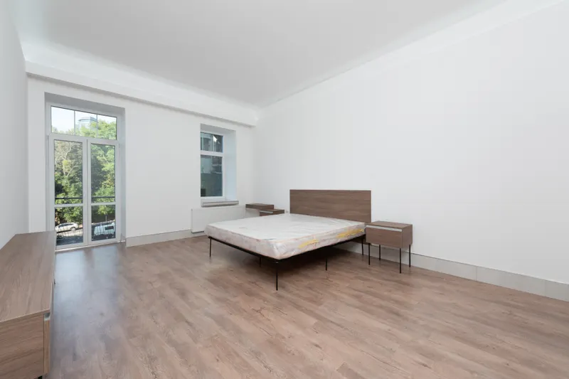 Segunda habitación con ventanas y suelo de madera