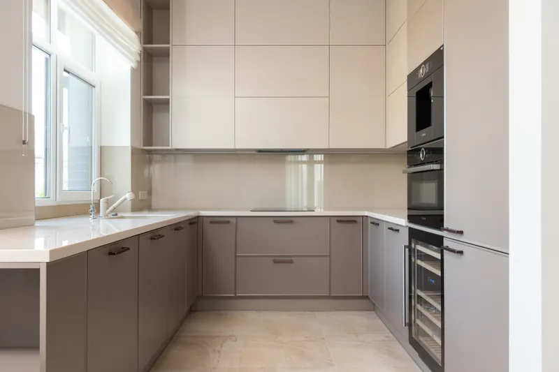 Cocina en L con encimera clara y ventana