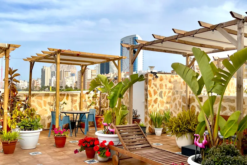 Terraza con pérgola de madera y macetas