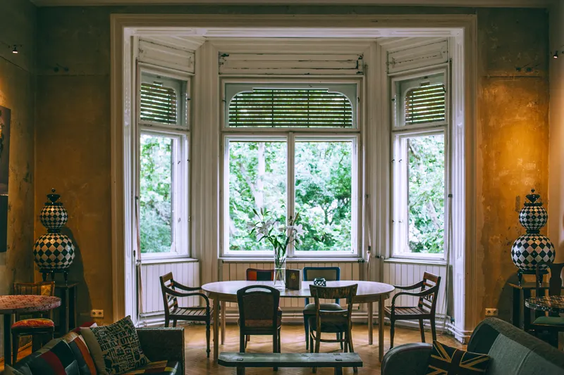 Comedor con mirador y mesa antigua junto a las ventanas
