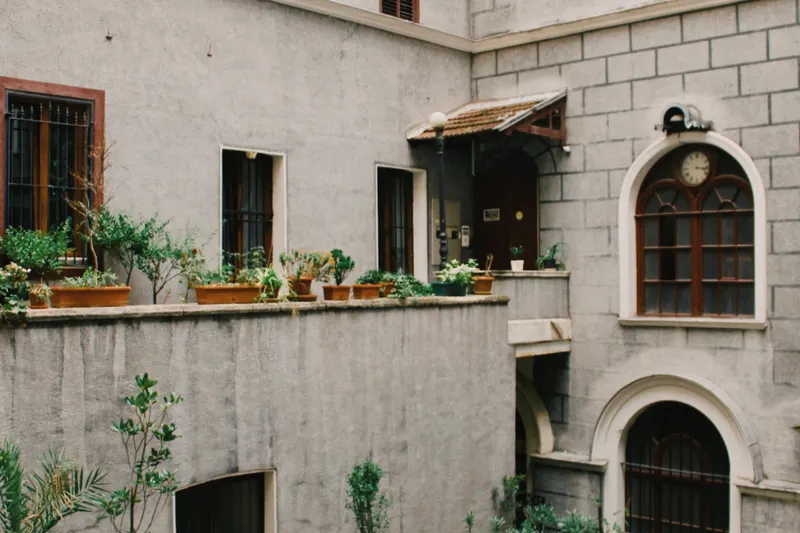 Patio de casa tradicional con macetas y ventana de arco